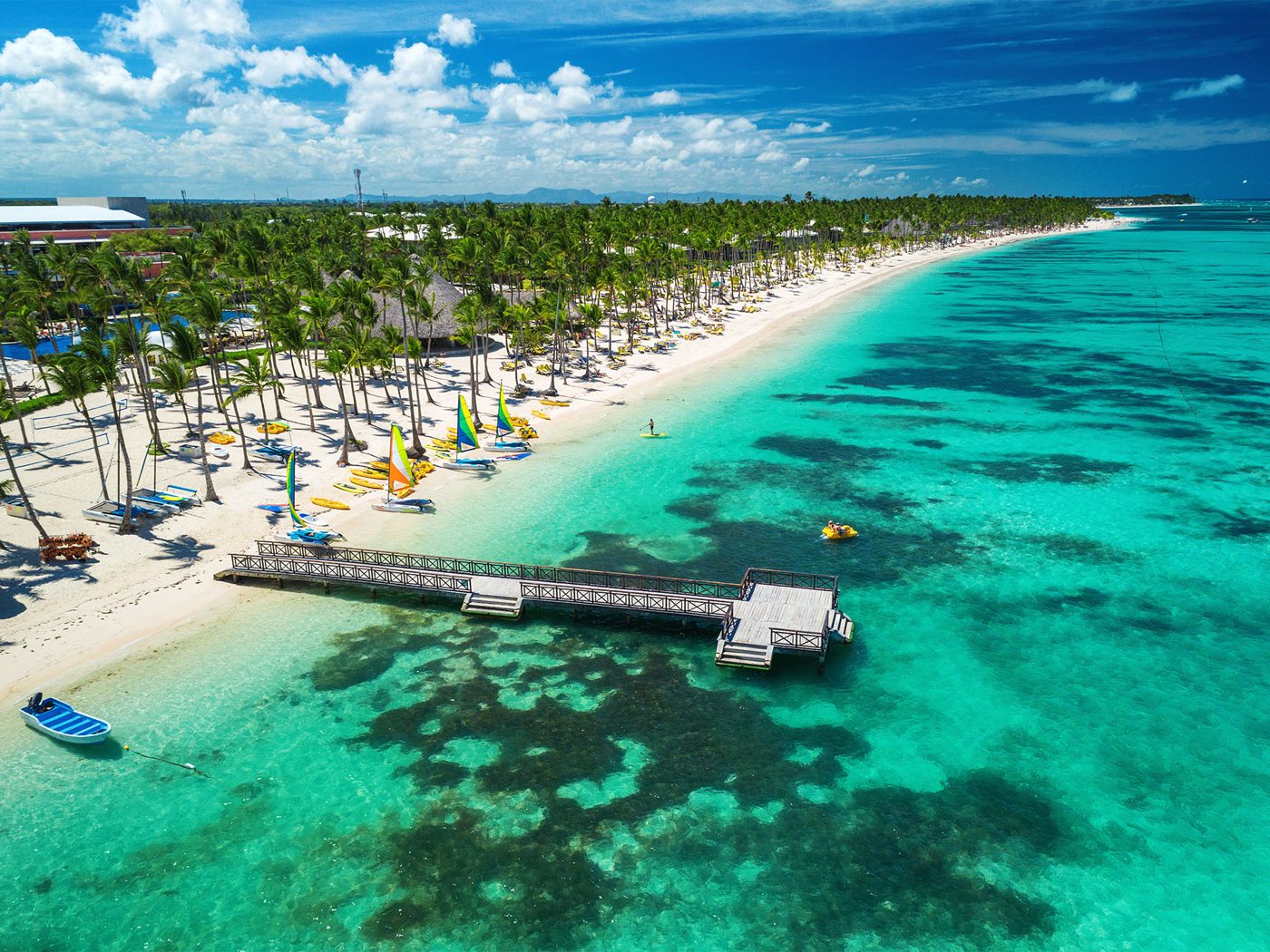 Vista aérea da praia de Bávaro em Punta Cana, com coqueiros e mar azul-turquesa